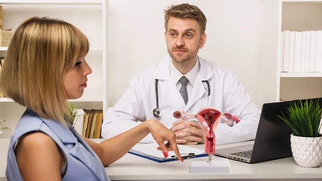 Giovane donna su una consultazione con un chirurgo o un terapista maschio nel suo ufficio