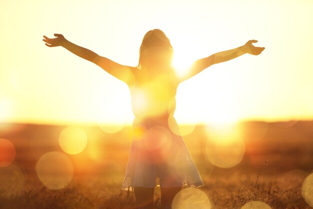 Giovane donna sul campo sotto la luce del tramonto