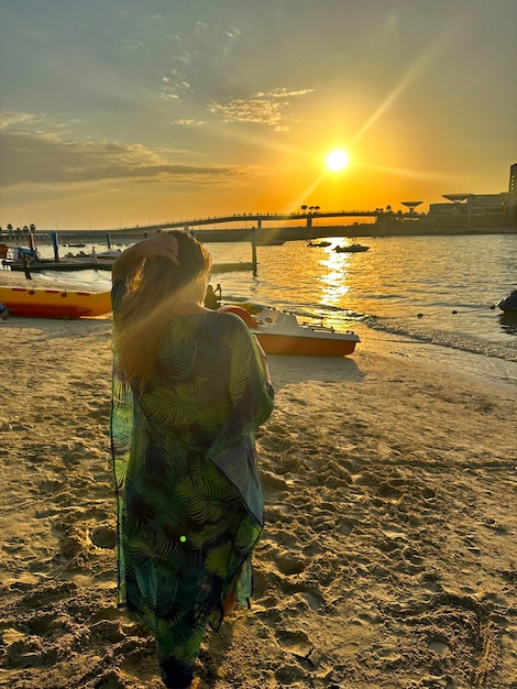 Giovane donna sul mare al tramonto in una nebbia nebbiosa