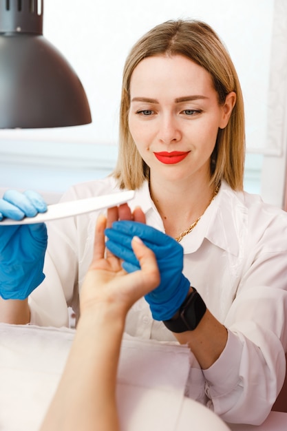 Giovane donna sul trattamento manicure nel salone di bellezza