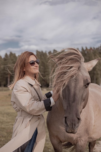 giovane donna sulla natura che cammina con il cavallo