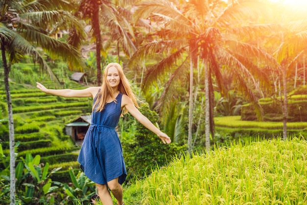 Giovane donna sulla piantagione di campo di riso a cascata verde sulla terrazza di Tegalalang. Bali, Indonesia. con la luce del sole