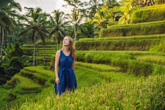 Giovane donna sulla piantagione di campo di riso a cascata verde sulla terrazza di Tegalalang. Bali, Indonesia