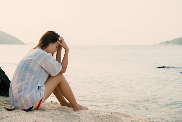 Giovane donna sulla spiaggia ed essere triste concept