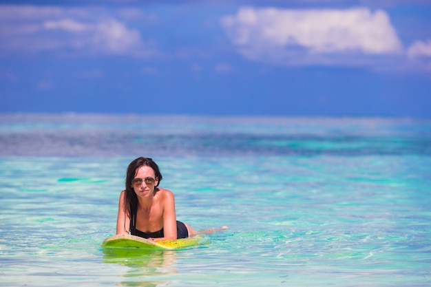 Giovane donna surfista surf durante la vacanza al mare