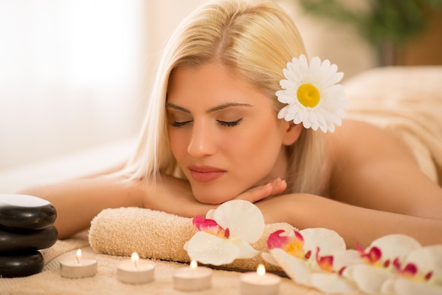 Giovane donna sveglia che si gode durante un trattamento per la cura della pelle in una spa.