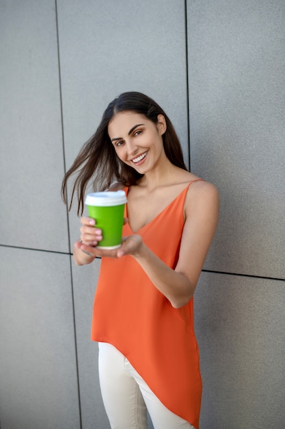 Giovane donna sveglia che tiene una tazza di caffè