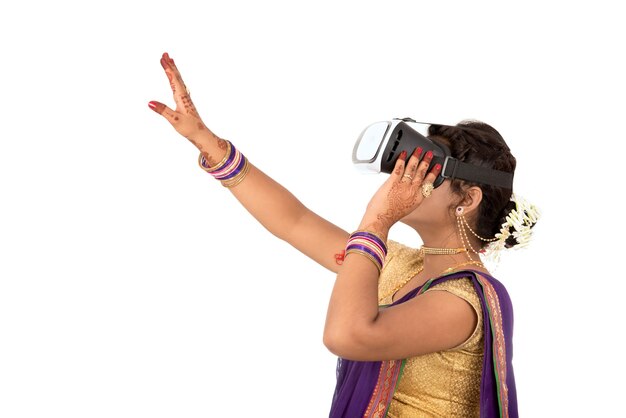 Giovane donna tradizionale indiana in saree che osserva se dispositivo di VR