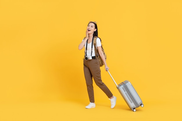 Giovane donna turistica asiatica con bagagli che vanno a viaggiare in vacanza