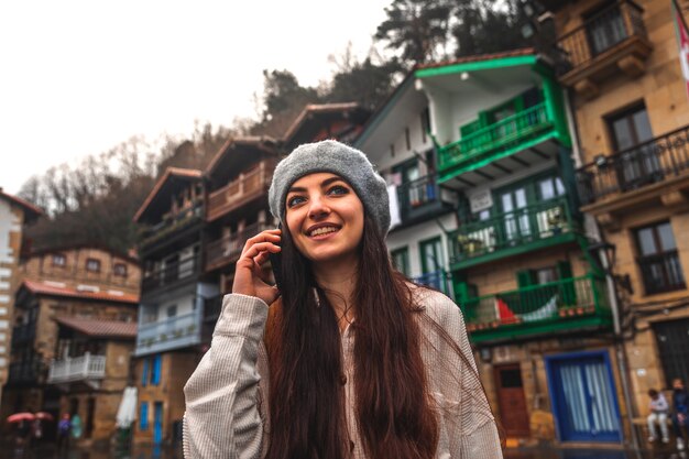 Giovane donna turistica caucasica che utilizza lo smartphone in una città vecchia.