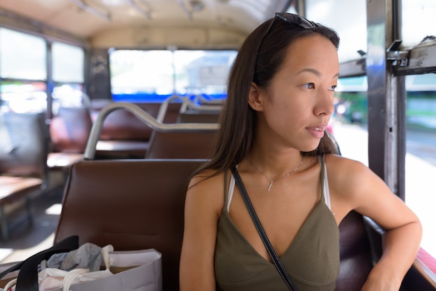 Giovane donna turistica che esplora la città di Bangkok con l'autobus