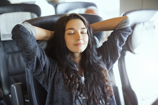 Giovane donna turistica che viaggia seduto in treno. Splendida razza mista felice asiatica caucasica