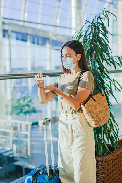 Giovane donna turistica in mascherina medica in aeroporto internazionale