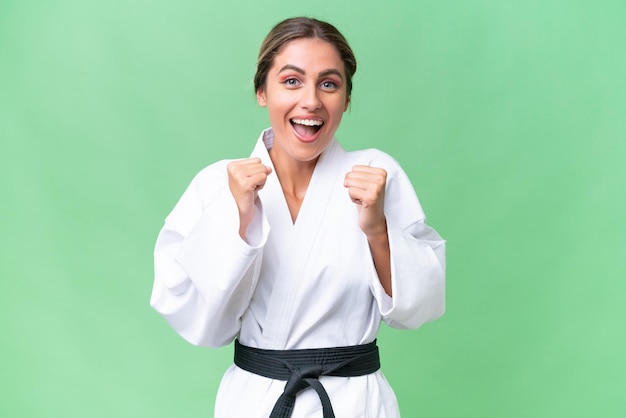Giovane donna uruguaiana che fa karate su sfondo isolato che celebra una vittoria nella posizione del vincitore
