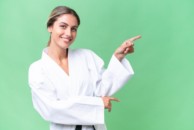 Giovane donna uruguaiana che fa karate su sfondo isolato che punta il dito verso il lato