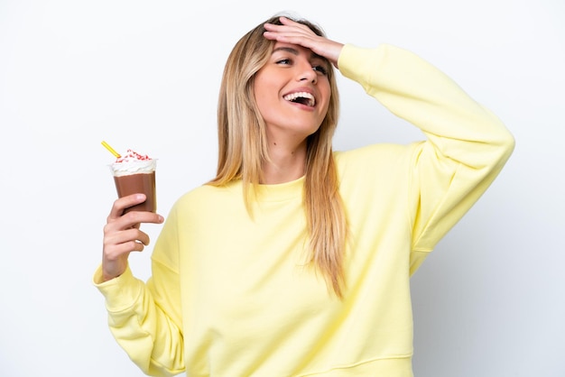 Giovane donna uruguaiana che tiene Frappuccino isolato su sfondo bianco sorridendo molto