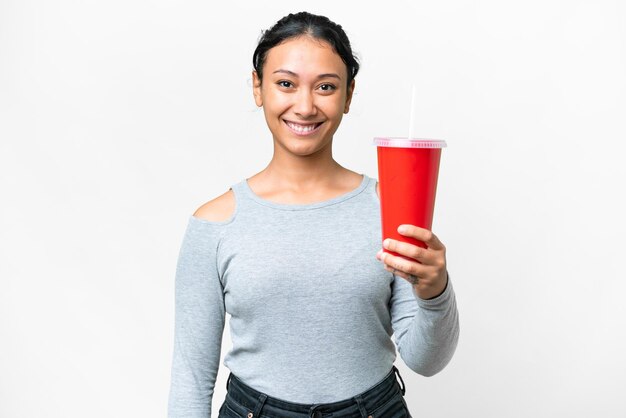 Giovane donna uruguaiana che tiene soda su sfondo bianco isolato con felice espressione