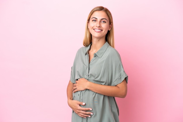 Giovane donna uruguaiana isolata su sfondo blu incinta e felice