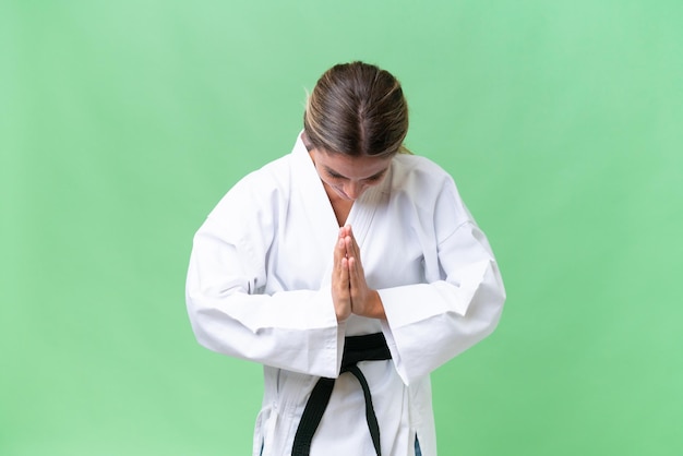 Giovane donna uruguaiana su sfondo isolato facendo karate e salutando