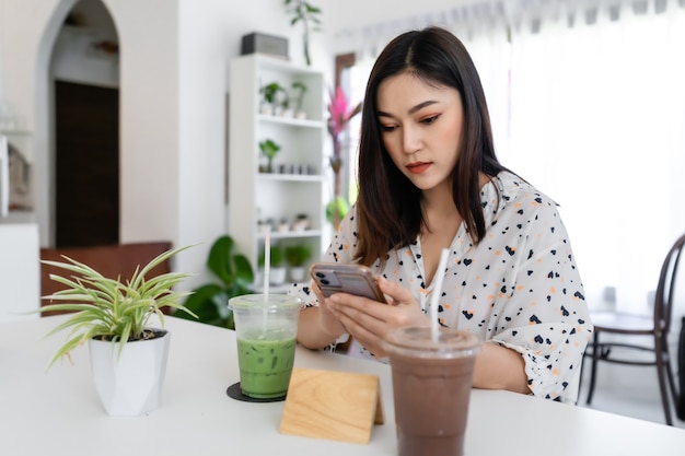 Giovane donna utilizza lo smartphone nella caffetteria