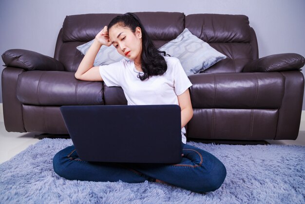 giovane donna utilizzando un computer portatile nel salotto di casa