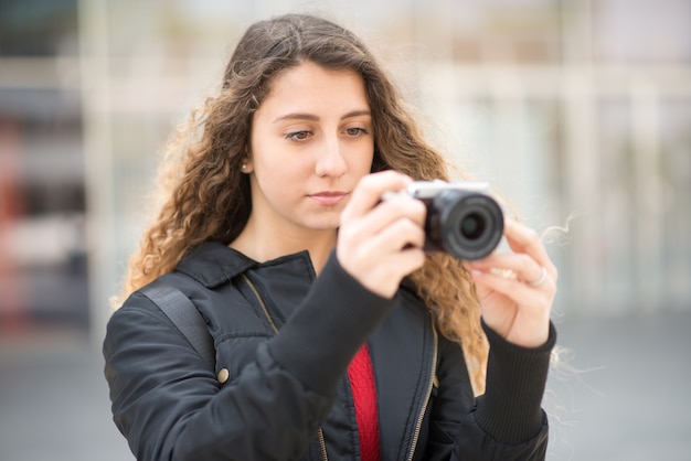 Giovane donna utilizzando una fotocamera mirrorless