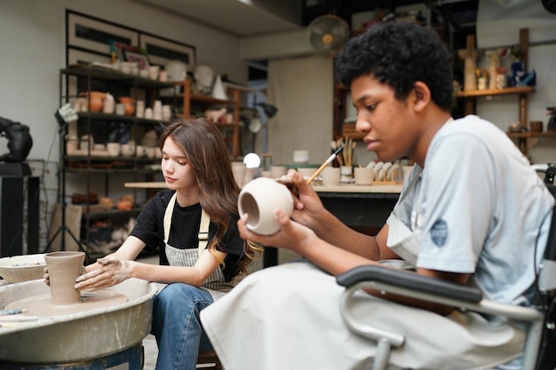 Giovane donna vasaio a mano che fa vaso di argilla nel laboratorio di ceramica Imprenditore