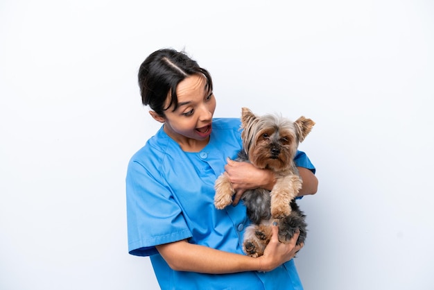 Giovane donna veterinaria con cane isolato su sfondo bianco con espressione facciale sorpresa e scioccata