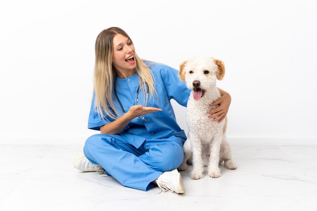 Giovane donna veterinaria con cane seduto sul pavimento