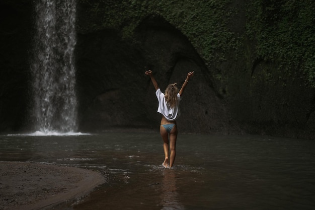 giovane donna viaggia per l'isola per scattare foto a una cascata