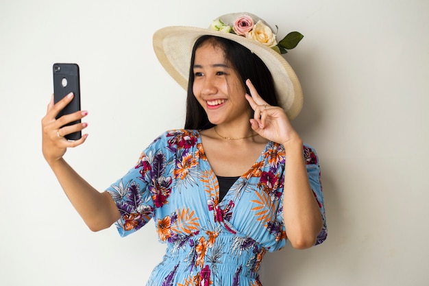 giovane donna viaggiatore sorriso felice prendere selfie. su sfondo bianco