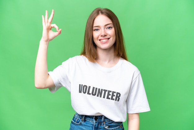 Giovane donna volontaria su sfondo chroma key isolato che mostra il segno ok con le dita