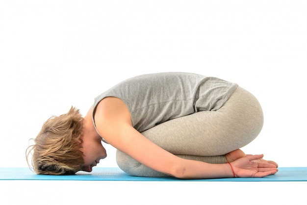 Giovane donna yoga impegnata nello yoga. Isolato sul muro bianco