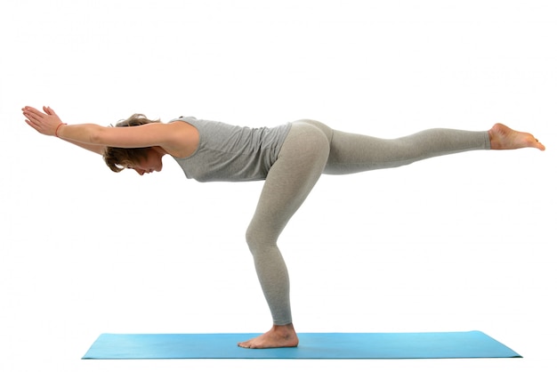 Giovane donna yoga impegnata nello yoga. Isolato sul muro bianco