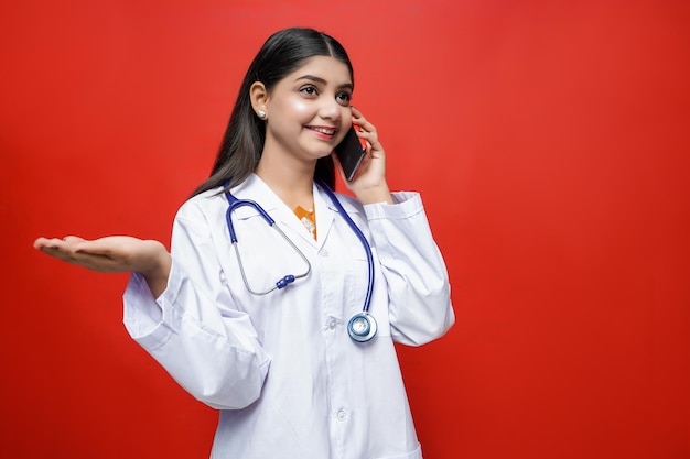 giovane dottoressa parlando al cellulare indossando cappotto e stetoscopio indiano modello pakistano