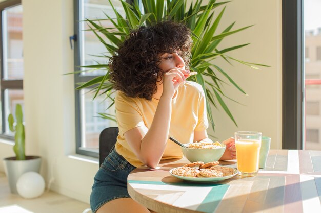 Giovane e bella donna araba facendo colazione a casa.