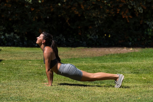 Giovane e bella donna che fa ginnastica nel giardino di casa sua in una giornata di sole dieta yoga sana