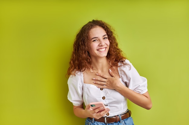 Giovane e bella ragazza caucasica in chat con un amico su smartphone