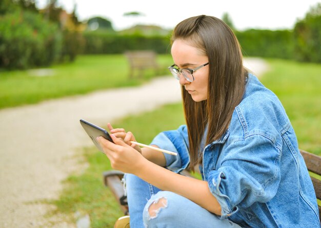 giovane e bella studentessa sta imparando all'aperto