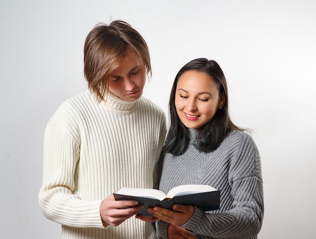 Giovane e donna che leggono insieme un libro