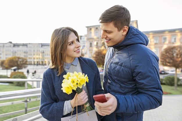 Giovane e donna con bouquet di fiori gialli