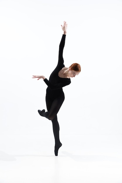 Giovane e graziosa ballerina in stile minimal nero isolato su bianco studio