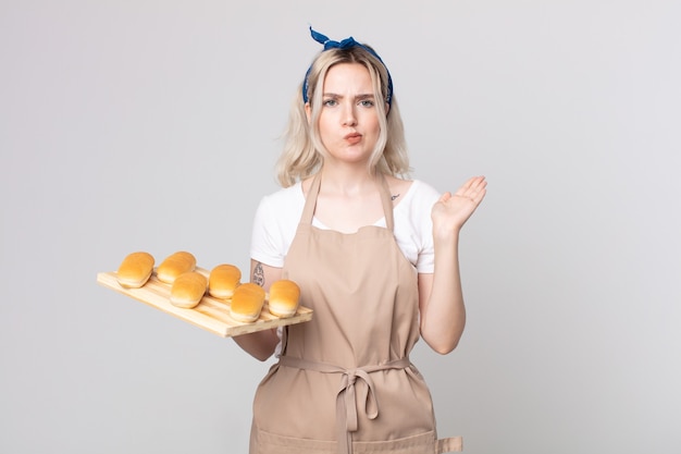 giovane e graziosa donna albina che si sente perplessa e confusa e dubita di un vassoio di focacce di pane