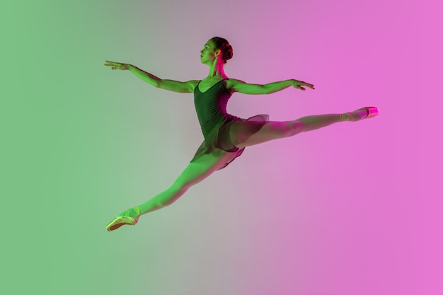 Giovane e grazioso ballerino isolato su sfondo sfumato rosa-verde studio
