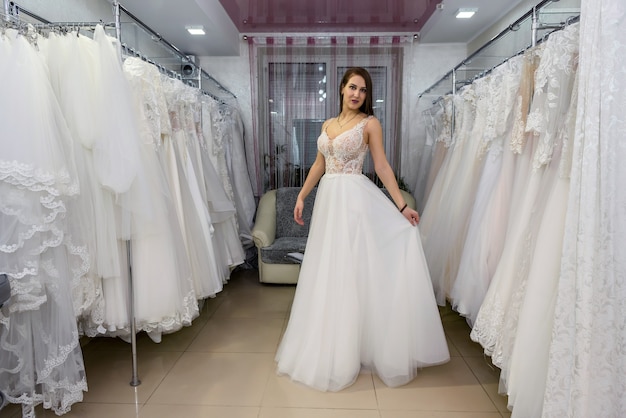 Giovane e piccola sposa in abito da sposa in salone