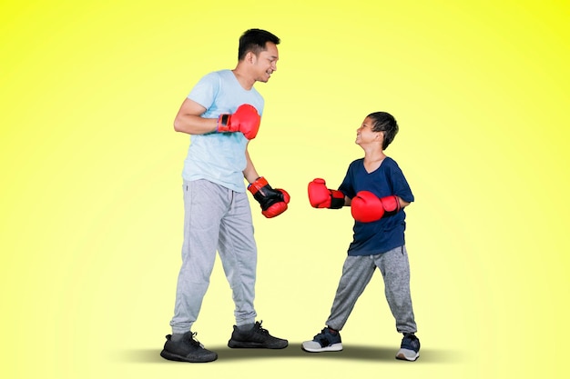 Giovane e suo figlio piccolo che fanno allenamento di boxe