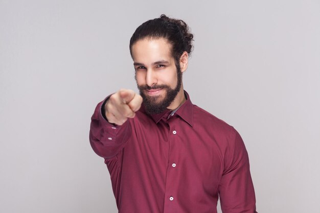 Giovane emotivo con la barba su sfondo grigio