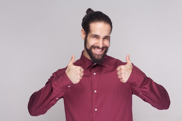 Giovane emotivo con la barba su sfondo grigio