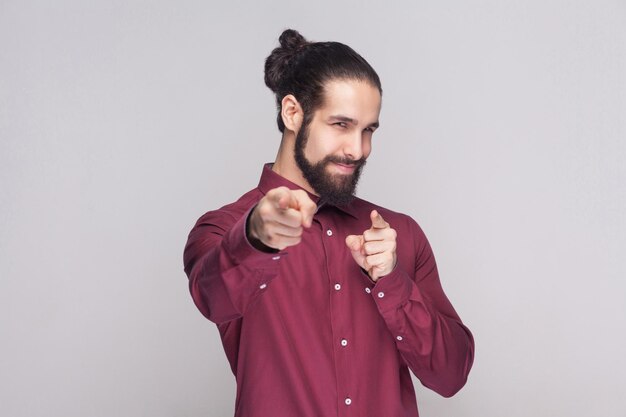 Giovane emotivo con la barba su sfondo grigio