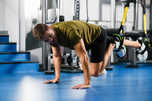 Giovane esercizio trx allenamento in palestra